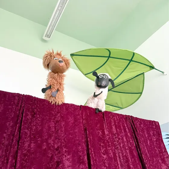 A dog and a sheep on the curtained stage