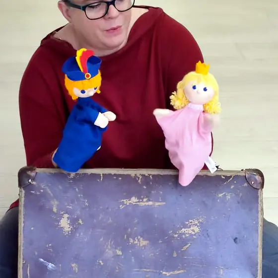 A prince and princess pop out of the suitcase